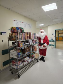 Santa Claus next to a shelf with board games and toys donated by Matex Bezbronni Foundation in hospital